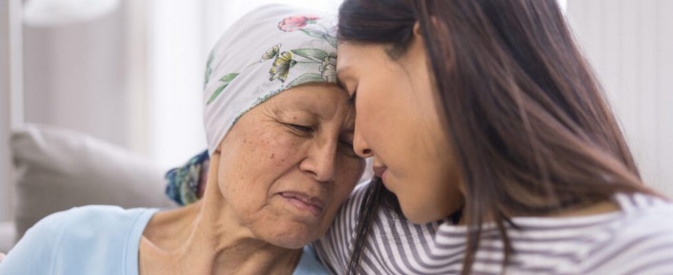 Ethnic elderly woman with cancer embracing her adult daughter